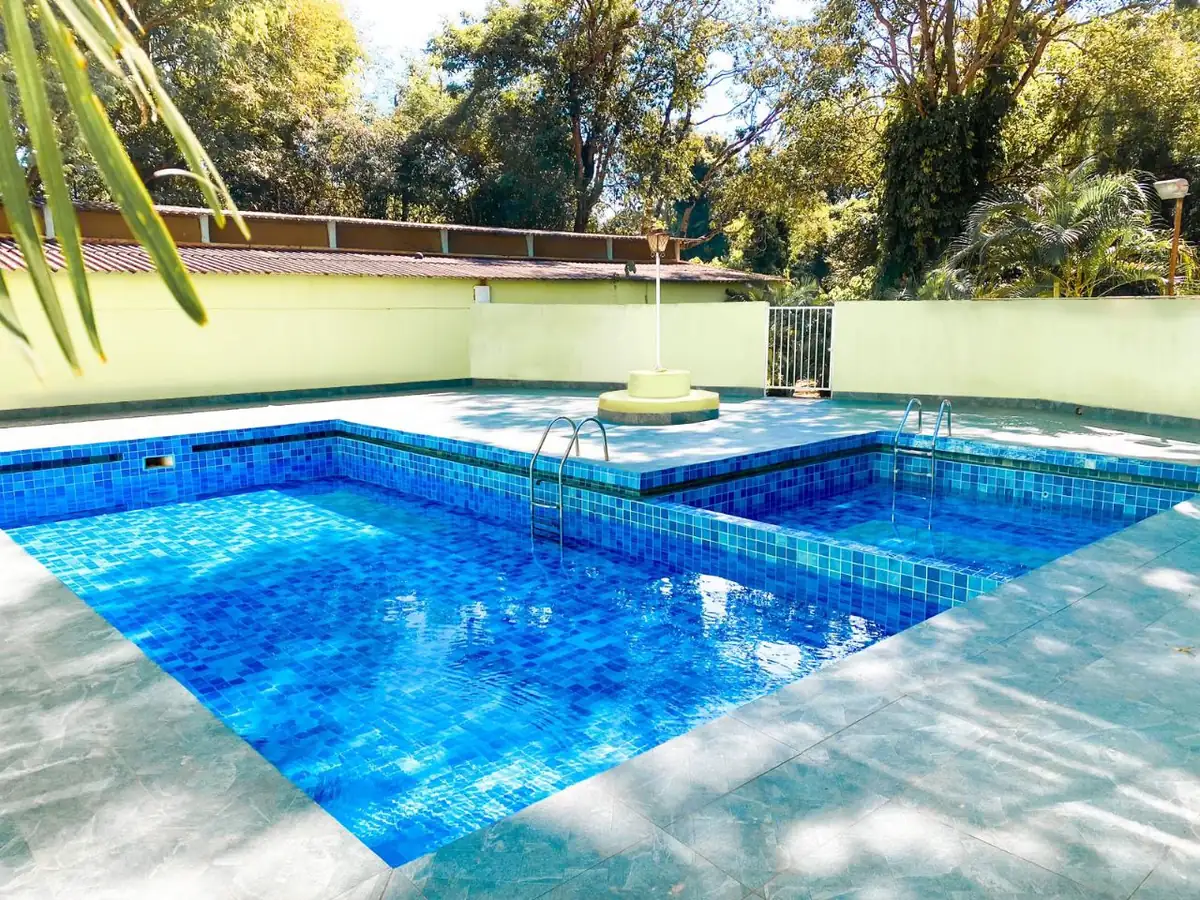 Piscinas adulto e infantil de azulejo azul sob o sol